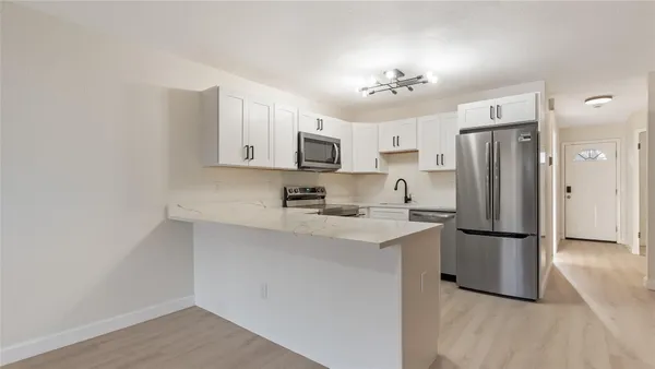 a kitchen with stainless steel appliances granite countertop a refrigerator oven a sink and dishwasher