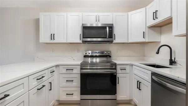 a kitchen with white cabinets and stainless steel appliances