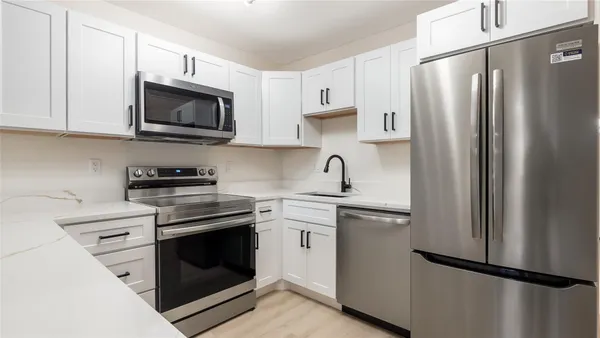 a kitchen with stainless steel appliances a refrigerator sink and microwave