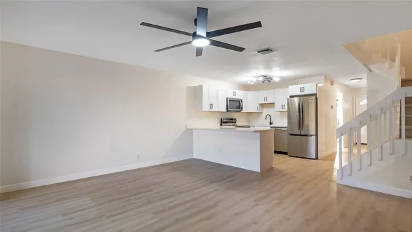 a kitchen with a refrigerator and white cabinets