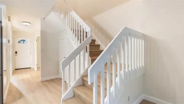 a view of staircase with railing and white walls
