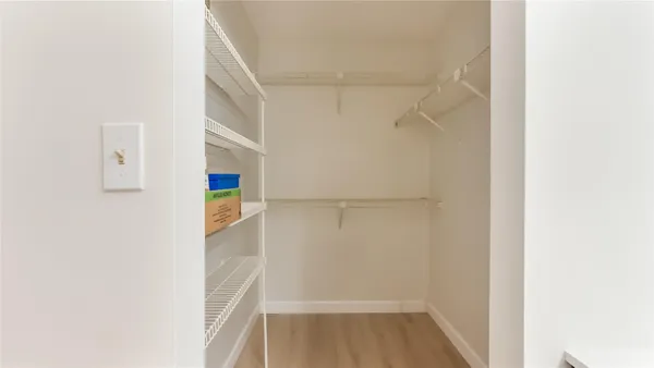 a view of walk in closet with empty racks