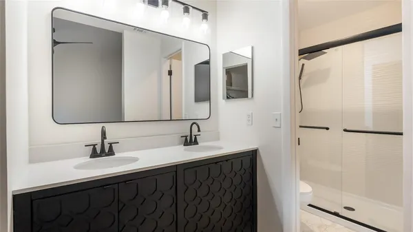 a bathroom with a double vanity sink and mirror