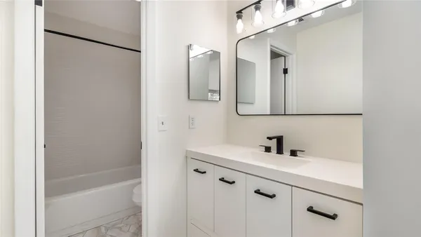 a bathroom with a bathtub a sink and mirror
