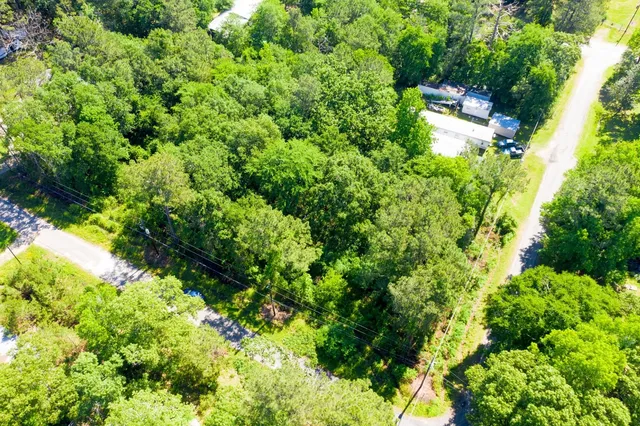 an aerial view of residential house with outdoor space and trees all around