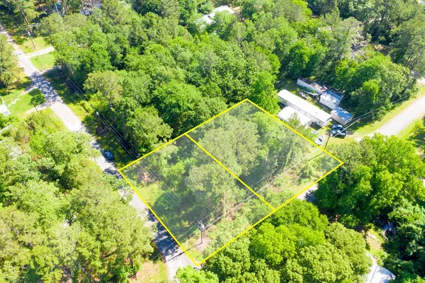an aerial view of residential house with outdoor space and trees all around
