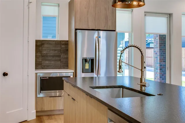 a kitchen with granite countertop a refrigerator and a stove top oven