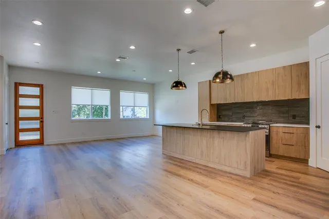 a kitchen with kitchen island granite countertop a stove and a sink