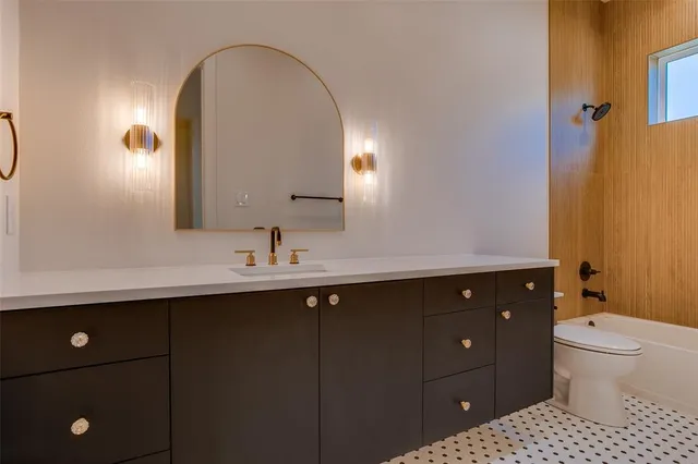 a bathroom with a double vanity sink toilet and a mirror