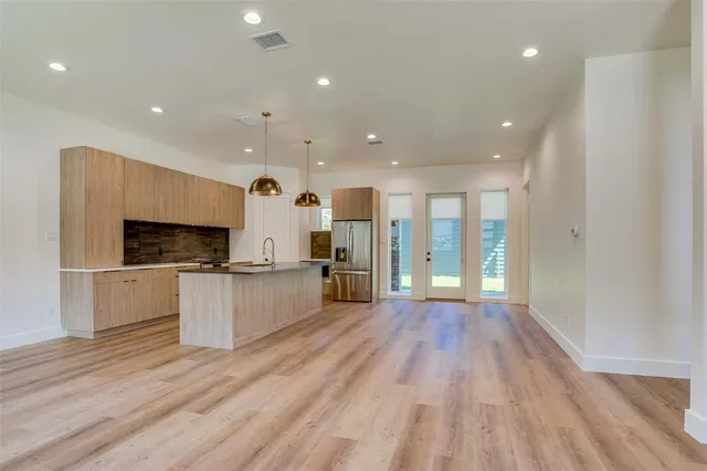 a view of a kitchen with kitchen island granite countertop a large window and stainless steel appliances