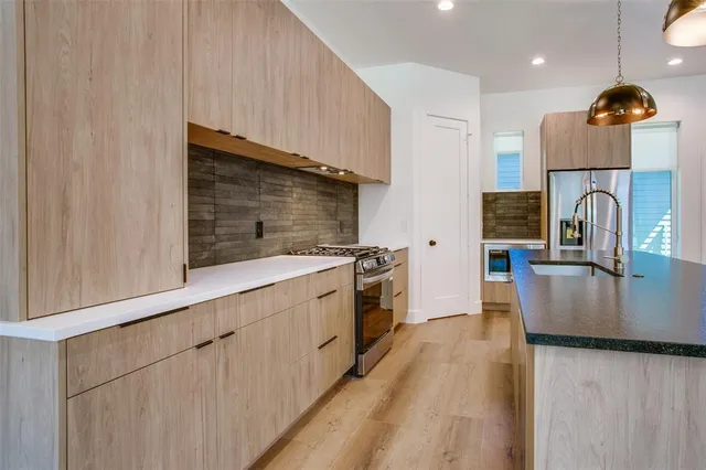 a kitchen with granite countertop a sink and a stove top oven with wooden floor