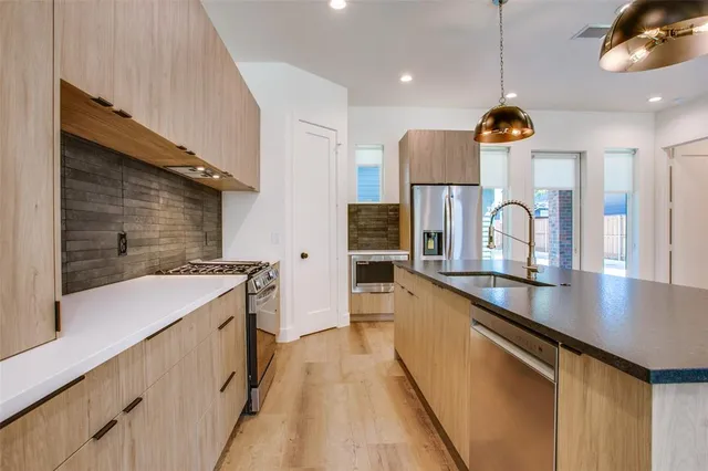 a kitchen with stainless steel appliances granite countertop a sink and a refrigerator