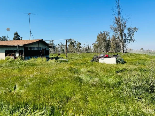 a view of a house with a big yard and large trees