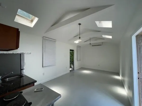 an empty room with stairs and windows