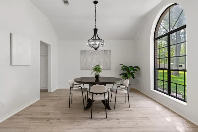 a dining room with furniture a potted plant and a chandelier