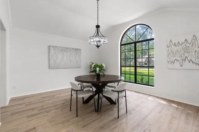 a dining room with furniture a chandelier and wooden floor