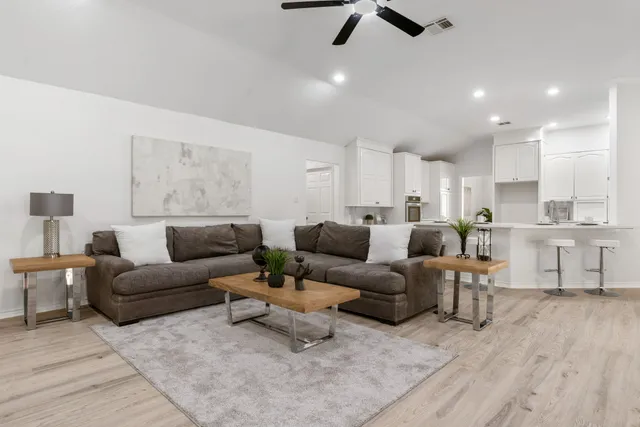 a living room with furniture and a wooden floor