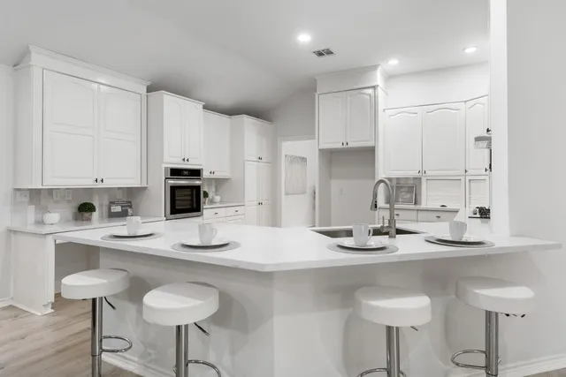 a kitchen with stainless steel appliances kitchen island granite countertop a sink and cabinets