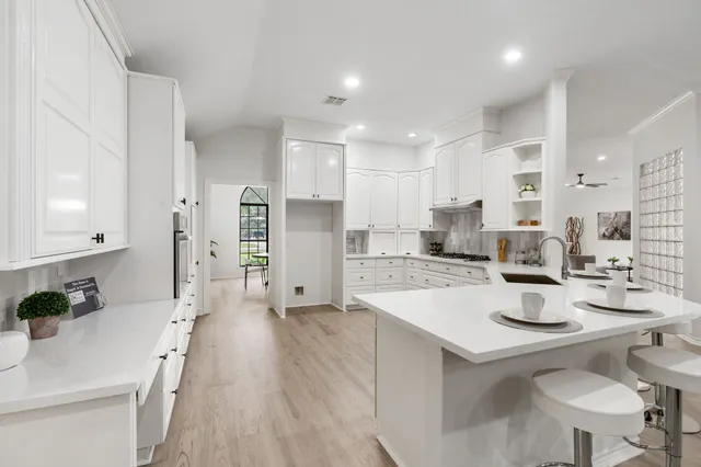 a kitchen with stainless steel appliances kitchen island granite countertop a sink refrigerator and cabinets