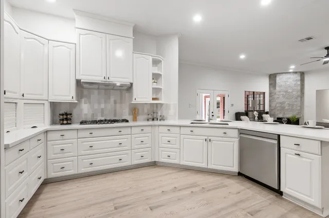 a kitchen with granite countertop white cabinets and white stainless steel appliances