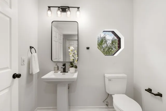 a bathroom with a toilet sink and mirror