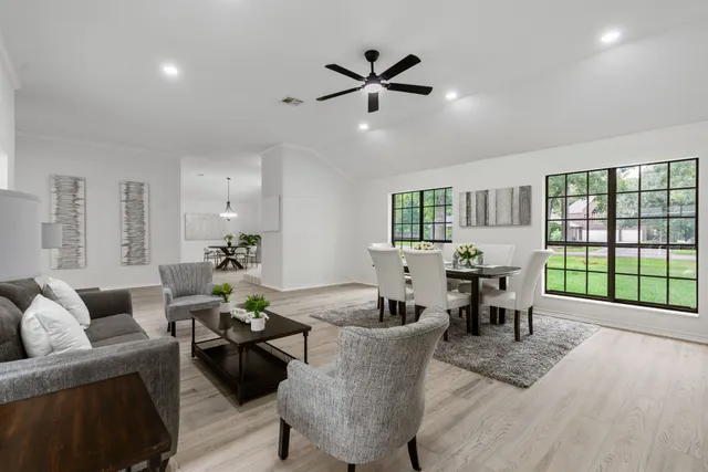 a living room with furniture and a large window with wooden floor