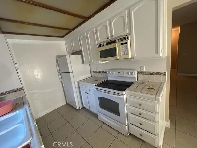 a kitchen with white cabinets and white appliances