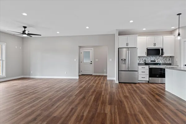 a view of kitchen with stainless steel appliances a refrigerator and a stove top oven