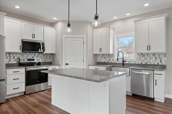 a kitchen with stainless steel appliances granite countertop a sink stove and refrigerator