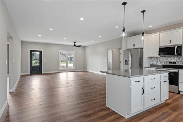 a view of kitchen with stainless steel appliances granite countertop cabinets and wooden floor