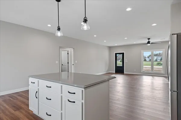 a view of a kitchen island a chandelier and wooden floor