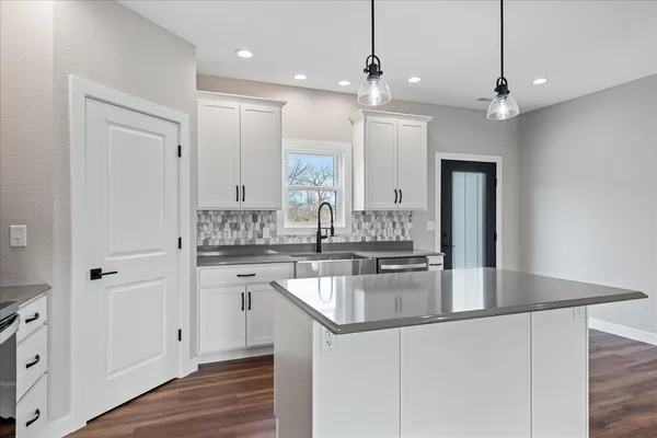 a kitchen with kitchen island granite countertop a sink center island stainless steel appliances and cabinets