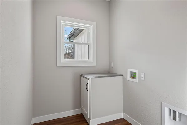 a view of an empty room with closet and wooden floor