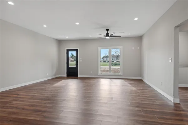 an empty room with window and wooden floor