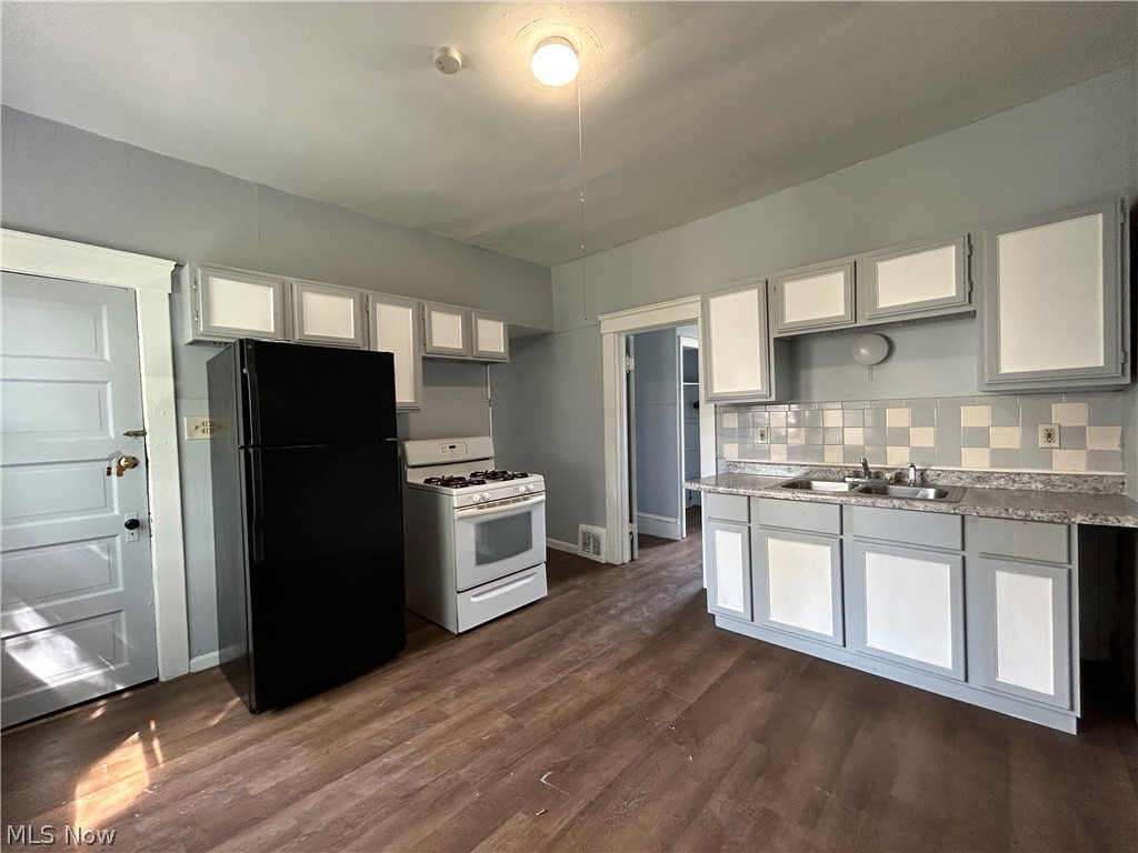3403 Fulton Road, Unit DOWN Cleveland, OH 44109 - Photo 15 of 18 Kitchen with white range with gas cooktop,dark hardwood / wood-style flooring, sink, white cabinetry, and black refrigerator