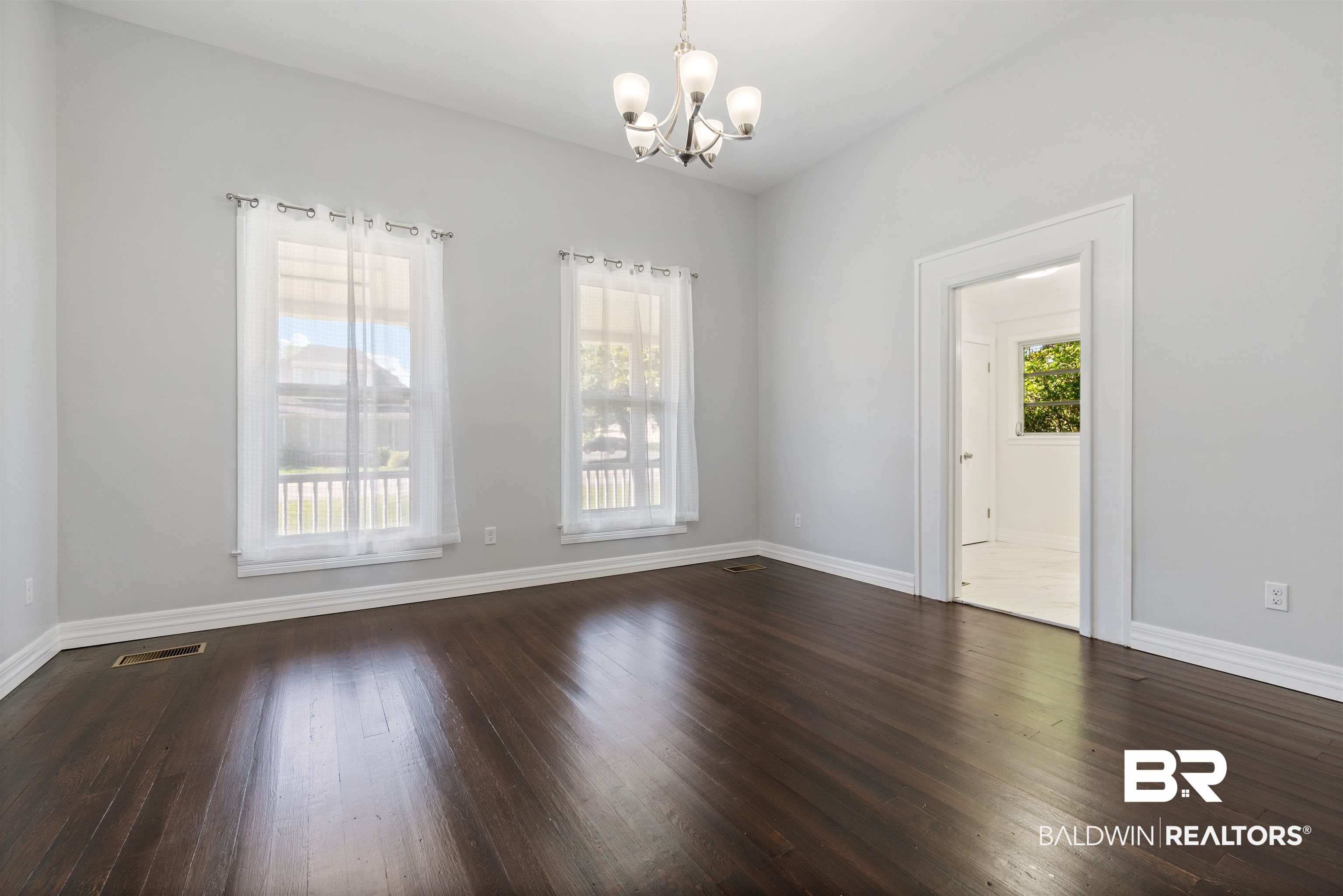407 East 2nd Street Bay Minette, AL 36507 - Photo 17 of 40 Unfurnished room with dark wood-style floors and a chandelier