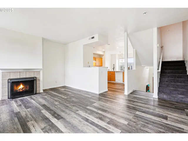 a view of a livingroom with wooden floor and a fireplace