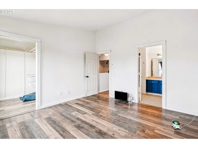 a view of empty room with wooden floor