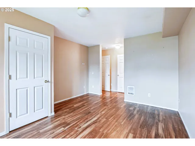 a view of an empty room with wooden floor