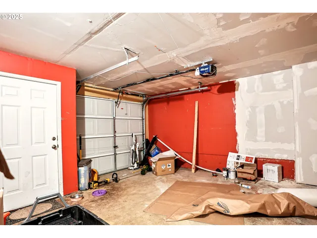a view of a yard with plants and brick wall