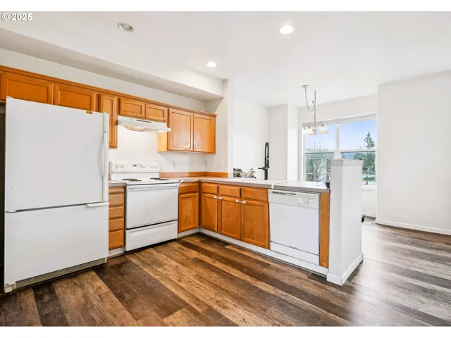 a kitchen with a refrigerator wooden floor