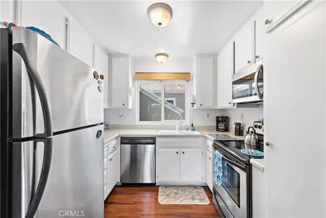 a kitchen with stainless steel appliances granite countertop a refrigerator sink and stove