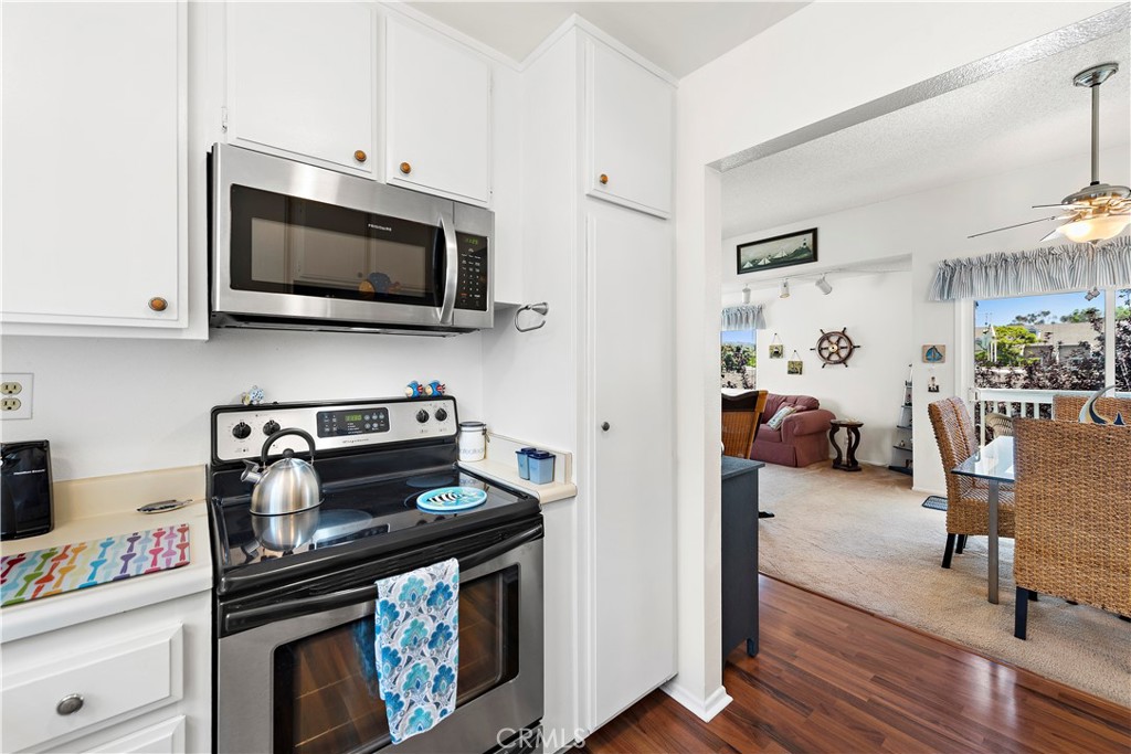 34110 Selva Road, Unit 321 Dana Point, CA 92629 - Photo 18 of 29 a kitchen with stainless steel appliances a stove a microwave and cabinets
