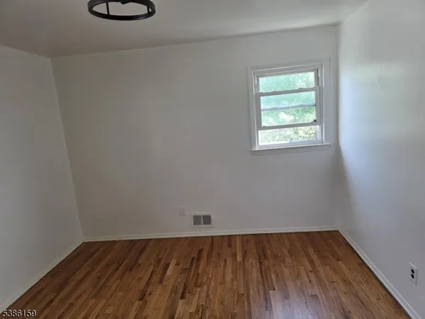 a view of a room with wooden floor and a window
