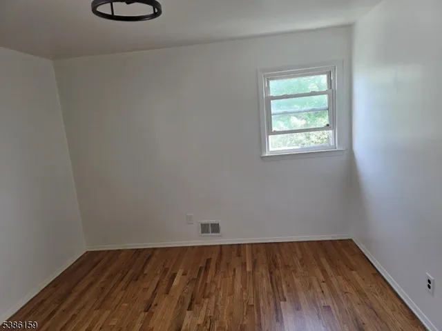 a view of a room with wooden floor and a window