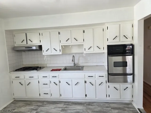 a kitchen with stainless steel appliances granite countertop a sink and a stove