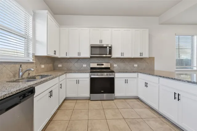 a kitchen with stainless steel appliances granite countertop a refrigerator sink and cabinets