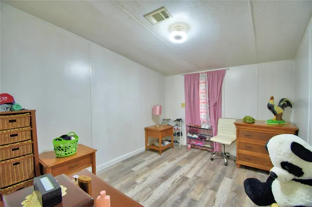 a living room with furniture two window and a flat screen tv