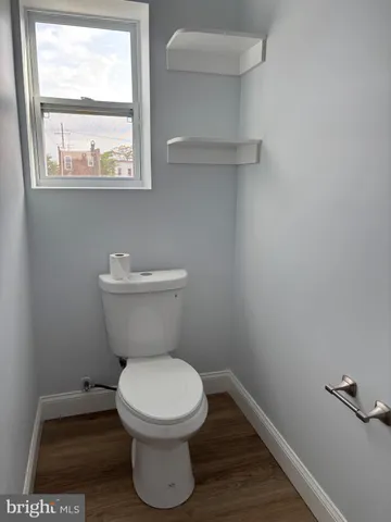 a white toilet sitting in a bathroom next to a window