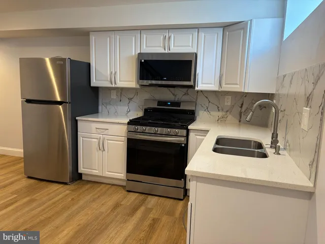 a kitchen with a stove a refrigerator and a microwave